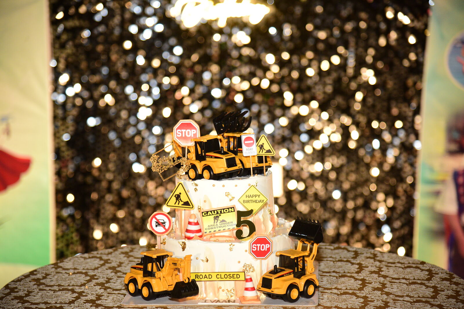 Themed cake centerpiece surrounded by bokeh fairy lights